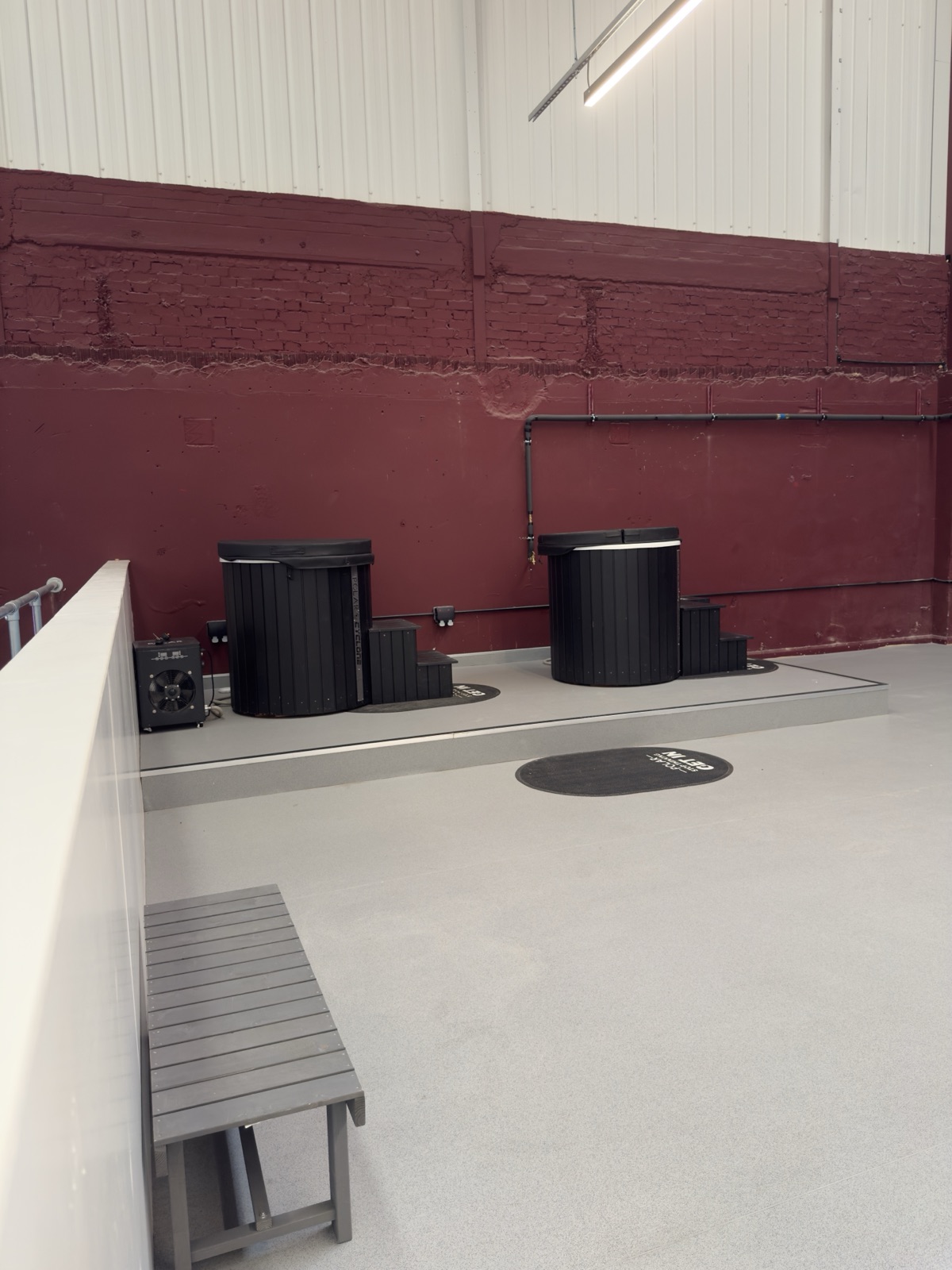 The makeshift wellness area at Racketeer: ice baths against an exposed brick wall.