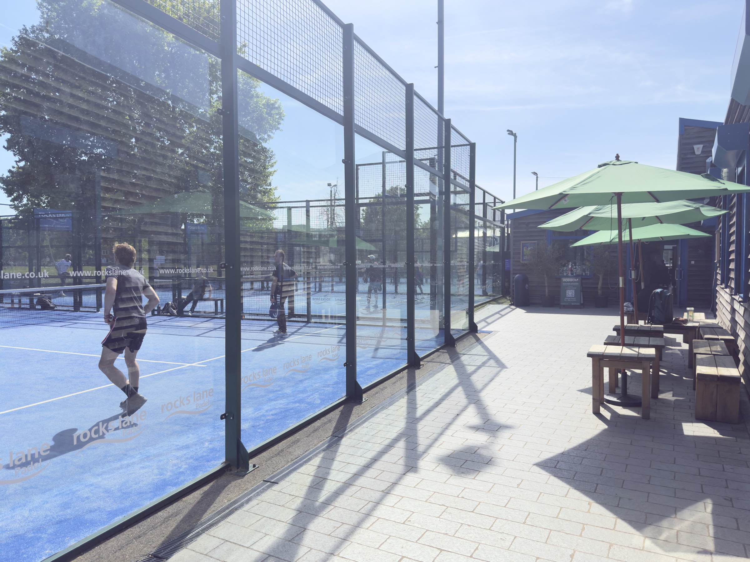 Outdoor padel courts at Rocks Lane Chiswick in late afternoon sun.
