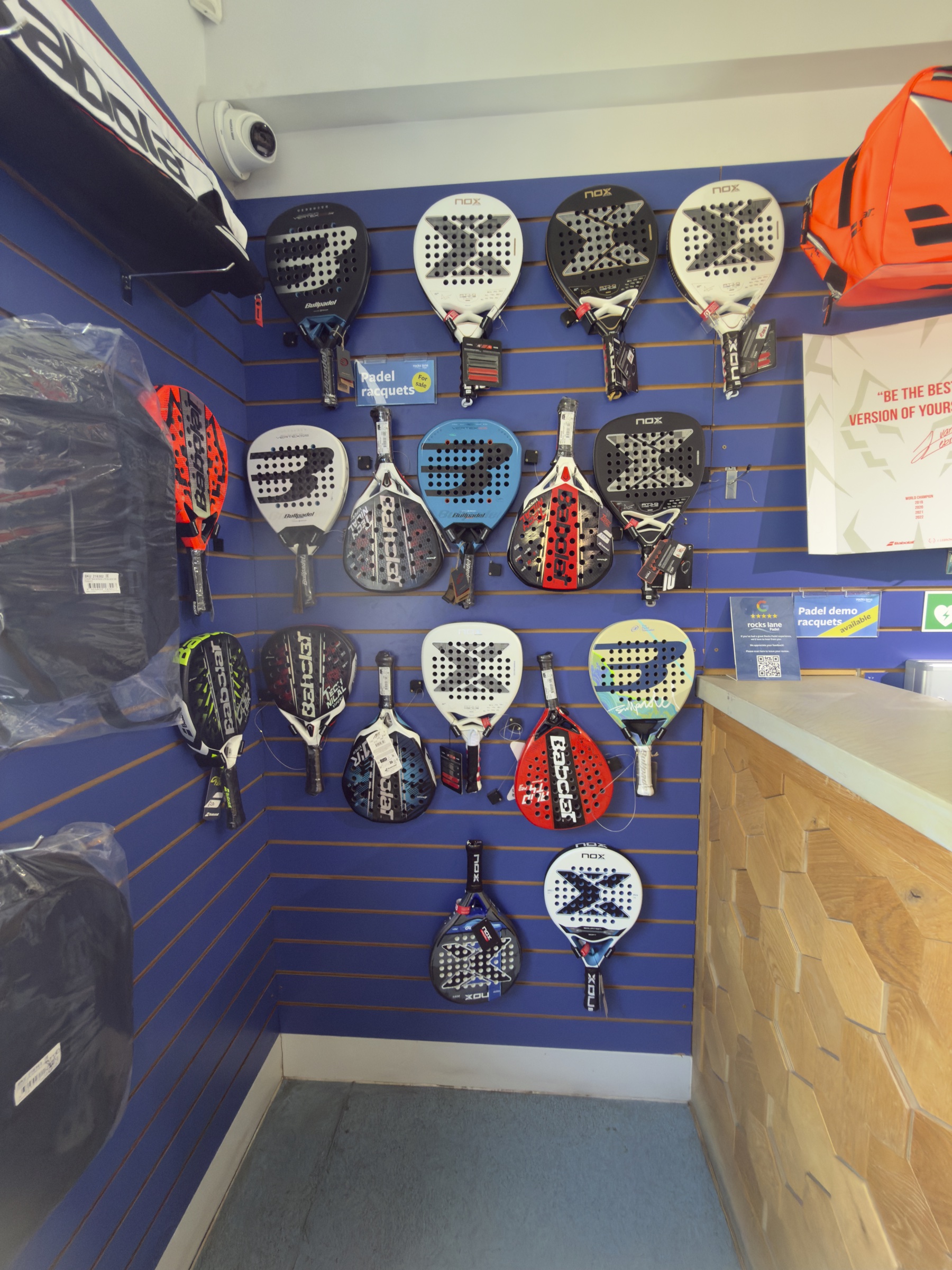 The pro shop wall at Rocks Lane Chiswick. Many rackets. One bag.